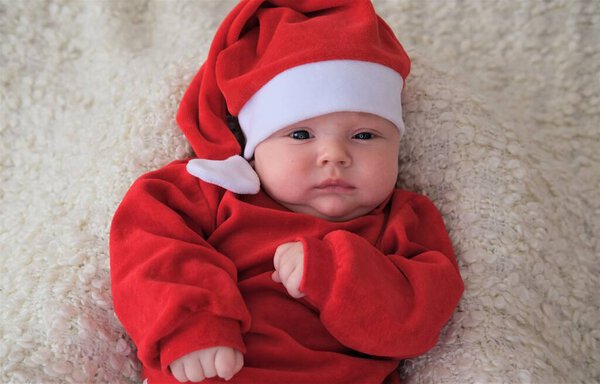 baby in santa costume on white background.Christmas toddler in Santa hat.Baby in red costume and hat.