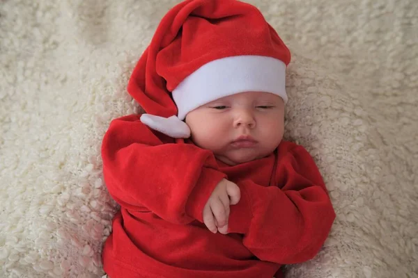 Baby im Weihnachtsmannkostüm auf weißem Hintergrund. Weihnachtskind mit Weihnachtsmannhut. Baby in rotem Kostüm und Hut. — Stockfoto