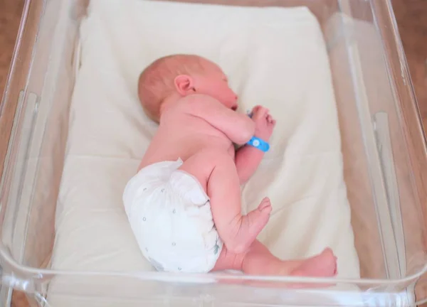 Neugeborenes - ein Junge oder ein Mädchen in einer Geburtsklinik schläft in einem Kinderbett, Konzept - Gesundheitsfürsorge und Medizin. — Stockfoto