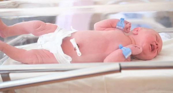 Neugeborenes - ein Junge oder ein Mädchen in einer Geburtsklinik schläft in einem Kinderbett, Konzept - Gesundheitsfürsorge und Medizin. — Stockfoto