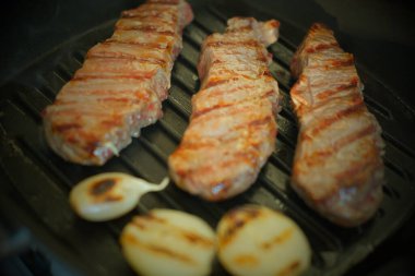 Kızarmış domuz eti ya da soğanlı sığır eti ızgaranın üstünde. Yakın plan et..