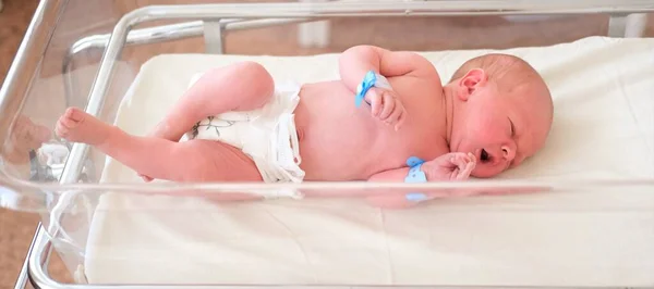 Bebé recién nacido - un niño o una niña en un hospital de maternidad duerme en una cuna, concepto - cuidado de la salud y medicina. — Foto de Stock