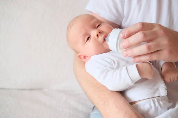 一位父亲抱着并给他的新生儿喂奶.3.宝宝的脸和头都长了红疹. — 图库照片
