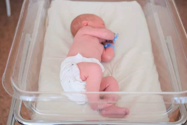 Bebé recién nacido - un niño o una niña en un hospital de maternidad duerme en una cuna, concepto - cuidado de la salud y medicina. — Foto de Stock