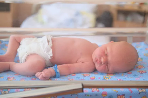 Новорожденный ребенок - мальчик или девочка в родильном доме спит в кроватке, концепция - здравоохранение и медицина. — стоковое фото