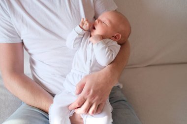 Bir baba üç aylık oğlunu kollarına alır..