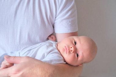 Bir baba üç aylık oğlunu kollarına alır..