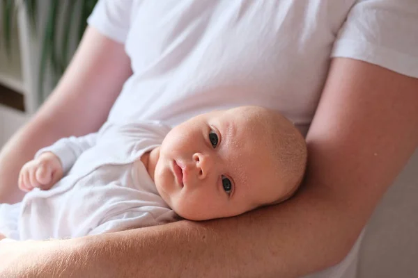 En far håller sin nyfödde son i sina armar.. — Stockfoto