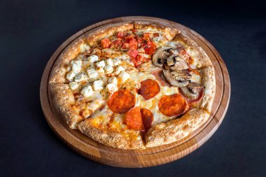 Pizza, tahta kesim tahtasının üzerinde, arka planda. Dört farklı pizza çeşidi. Mesaj için yer var. Yukarıdan görünüşü.