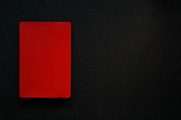 黒の革の背景に赤いノート 左端のノート 黒い背景の赤い四角形 — ストック写真
