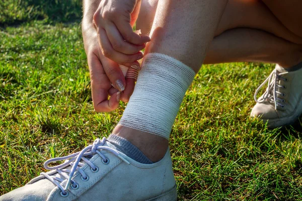 Young Woman Bandaging Injured Ankle Injury Leg While Running Outdoors — Stock Photo, Image