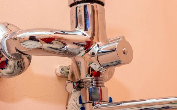 Installation of the spout of the water tap in the bathroom. Screwing in the nut of the water mixer. — Stock Photo, Image