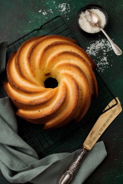 Şeker sır ve koyu yeşil eski beton zemin üzerine Hindistan cevizi ile kek. Seçici odak. Kopya alanı ile üstten görünüm.