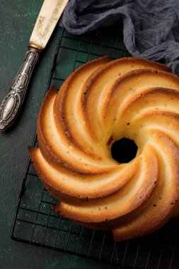 Şeker sır ve koyu yeşil eski beton zemin üzerine Hindistan cevizi ile kek. Seçici odak. Kopya alanı ile üstten görünüm.