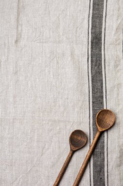 Doku kahverengi şerit ve iki ahşap eski vintage kaşık ile gri kumaş. Kopya alanı ile üstten görünüm.