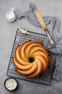 Şeker sır ve koyu gri eski beton zemin üzerine Hindistan cevizi ile kek. Seçici odak. Kopya alanı ile üstten görünüm.