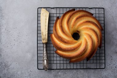 Şeker sır ve koyu gri eski beton zemin üzerine Hindistan cevizi ile kek. Seçici odak. Kopya alanı ile üstten görünüm.