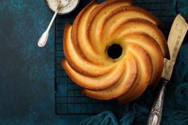 Şeker sır ve koyu mavi eski beton zemin üzerine Hindistan cevizi ile kek. Seçici odak. Kopya alanı ile üstten görünüm.
