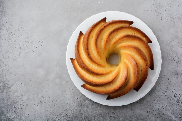 Şeker sır ve koyu gri eski beton zemin üzerine Hindistan cevizi ile kek. Seçici odak. Kopya alanı ile üstten görünüm.