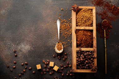 Food background with three kinds of coffee: beans, milled, instant in wooden box on old concrete brown background. Rustic stile. Selective focus. Top view. clipart