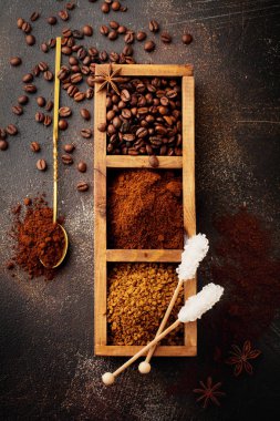 Üç çeşit kahve ile gıda arka plan: fasulye, öğütülmüş, anlık eski beton kahverengi zemin ahşap kutusunda. Rustik stile. Seçici odak. Üstten görünüm.