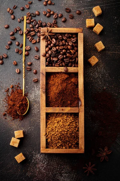 Üç çeşit kahve ile gıda arka plan: fasulye, öğütülmüş, anlık eski beton kahverengi zemin ahşap kutusunda. Rustik stile. Seçici odak. Üstten görünüm.