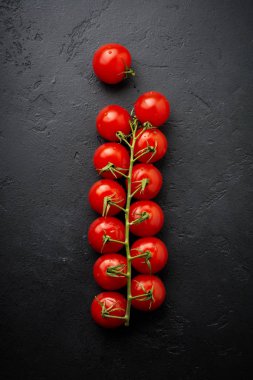 Siyah arka plan üzerine Ham taze kiraz domates dalı. Gıda arka plan. Seçici odak. Üstten görünüm.