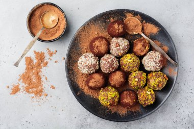 Ev yapımı koyu çikolata truffles kakao tozu, Antep fıstığı, badem açık gri renkli doku içinde çeşididir. Üstten görünüm, kopya alanı.