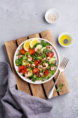 Roka, salatalık, domates ve karides salatası soya sosu bir seramik tabak. Seçici odak. Üstten görünüm.