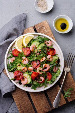 Roka, salatalık, domates ve karides salatası soya sosu bir seramik tabak. Seçici odak. Üstten görünüm.