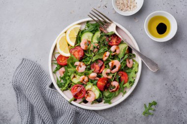 Roka, salatalık, domates ve karides salatası soya sosu bir seramik tabak. Seçici odak. Üstten görünüm.