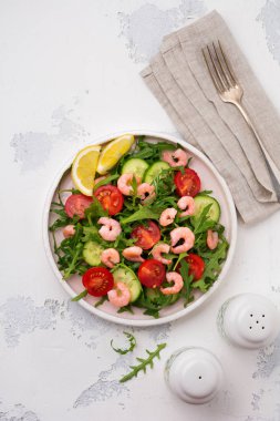 Roka, salatalık, domates ve karides salatası soya sosu bir seramik tabak. Seçici odak. Üstten görünüm.