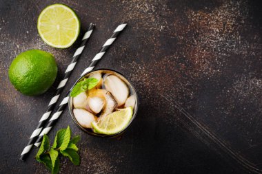 Cola, viski, kireç ve likör bardak koyu beton eski arka plan üzerinde alkollü içecek soğutma yaz. Üstten görünüm.