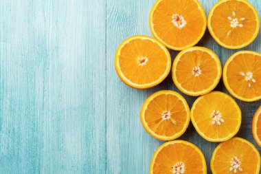 Portakal dilimleri düz rustik mavi ahşap arka plan üzerinde yatıyordu. Üstten görünüm.