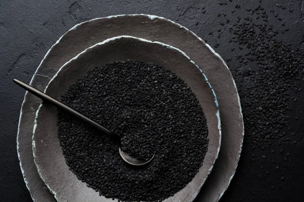 Graines Sésame Noir Dans Des Assiettes Céramique Noire Sur Fond — Photo