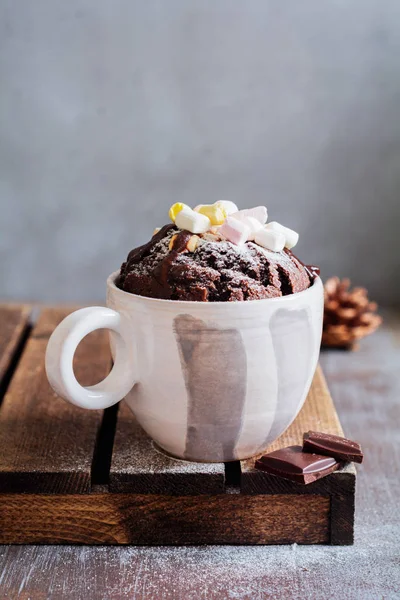 New Year\'s chocolate cake cooked in microwave oven in mug on vintage gray background texture. Top view.New Year card