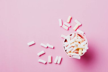 Marshmallow ile boşaltmak pembe arka plan üzerinde. Düz yatıyordu. Arka plan veya doku renkli mini lokum gibiydi. 