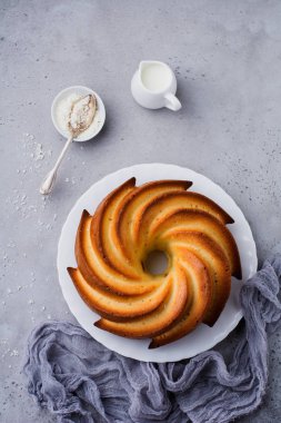 Şeker sır ve koyu gri eski beton zemin üzerine Hindistan cevizi ile kek. Seçici odak. Kopya alanı ile üstten görünüm.