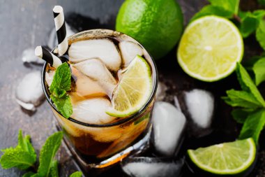 Cola, viski, kireç ve likör bardak koyu beton eski arka plan üzerinde alkollü içecek soğutma yaz.