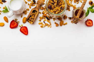 Yulaf ezmesi granola cam beyaz zemin üzerine kurutulmuş meyve, chia tohum ve ayçiçeği, tatlım. Üstten görünüm. 