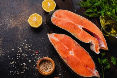 Oda arkadaşı somon ile baharat, ot, tuz ve limon eski taş zemin üzerine çiğ biftek. Üstten görünüm kopya alanı.