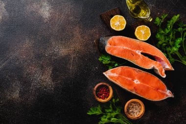 Oda arkadaşı somon ile baharat, ot, tuz ve limon eski taş zemin üzerine çiğ biftek. Üstten görünüm kopya alanı.