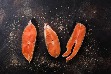 Oda arkadaşı somon ile baharat, ot, tuz ve limon eski taş zemin üzerine çiğ biftek. Üstten görünüm kopya alanı.