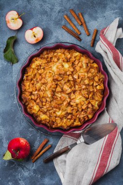 Ceviz ve eski bir beton zemin üzerine krema ile ev yapımı pasta elma ve tarçın. Rustik tarzı. Üstten görünüm.