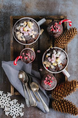 Grup yeni yıl çikolatalı kek vintage gri arka plan doku mug içinde mikrodalga fırında pişirilir. Üstten görünüm. Yeni yıl kartı