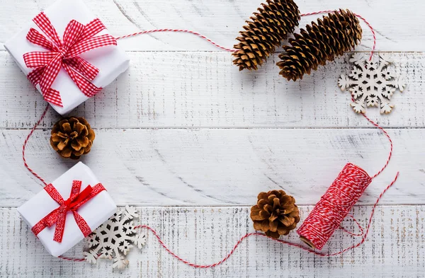 Kerstmis Achtergrond Met Rood Lint Speelgoed Geschenkdozen Dennenappels Witte Houten — Stockfoto