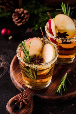 Geleneksel Noel elma tarçın, anason ve dal biberiye koyu arka plan masaya yumruk at. Seçici odak. Üstten görünüm.