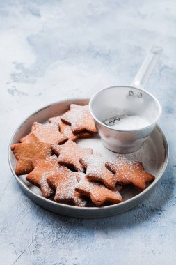 Ev yapımı yılbaşı yeni yıl yıldız şekli gingerbread çerezleri eski beton gri antika arka plan üzerinde seramik plaka. Üstten görünüm alanı ile.