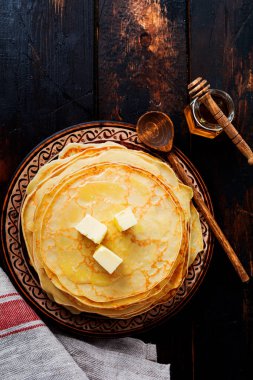 Adet tereyağı, süt ve bal eski Rustik Seramik plaka üzerinde ev yapımı ince krep yığını. Üstten Görünüm 