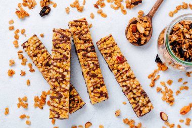 Fındık, meyve ve çilek whhite taş masada Mısır gevreği granola bar. Granola bar. Sağlıklı snack. Üstten Görünüm.